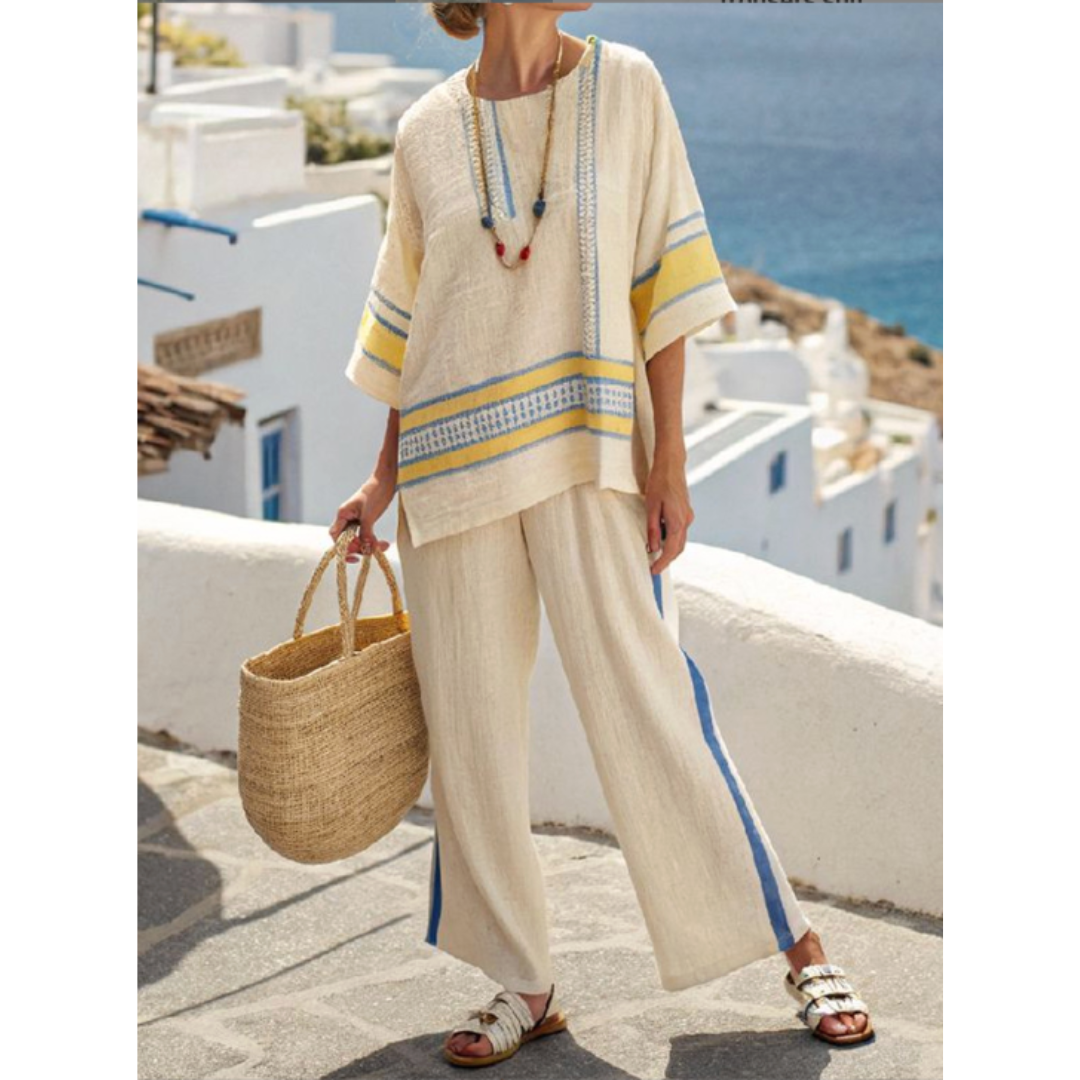 Woman wearing a striped two-piece top and skirt set against a beach background.
