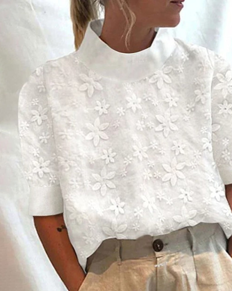  Female model showcasing a refined floral blouse with a relaxed shape on a plain background.