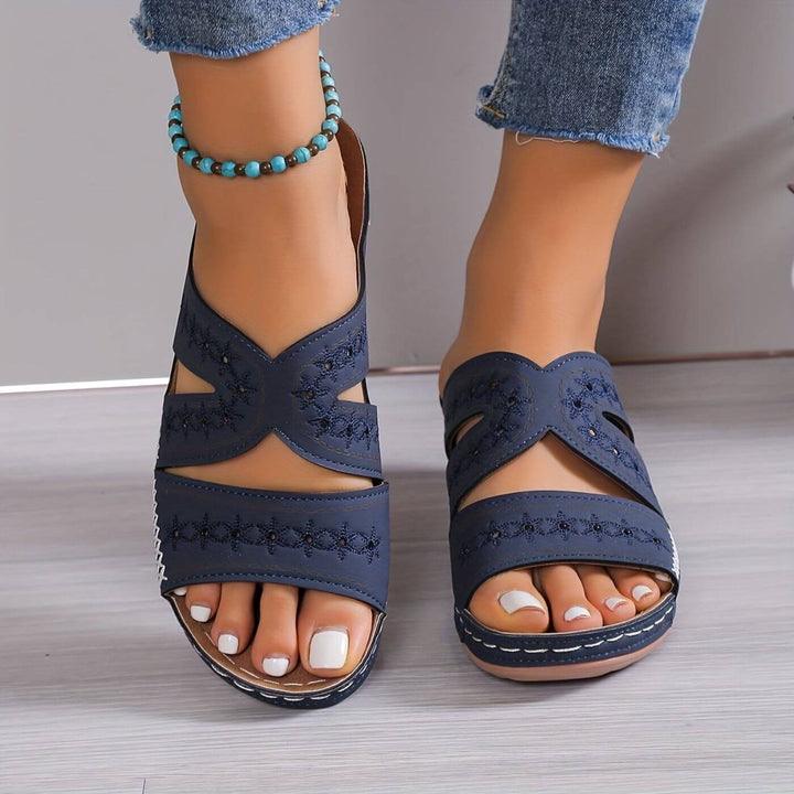  Woman showcasing everyday walking sandals on a plain background.