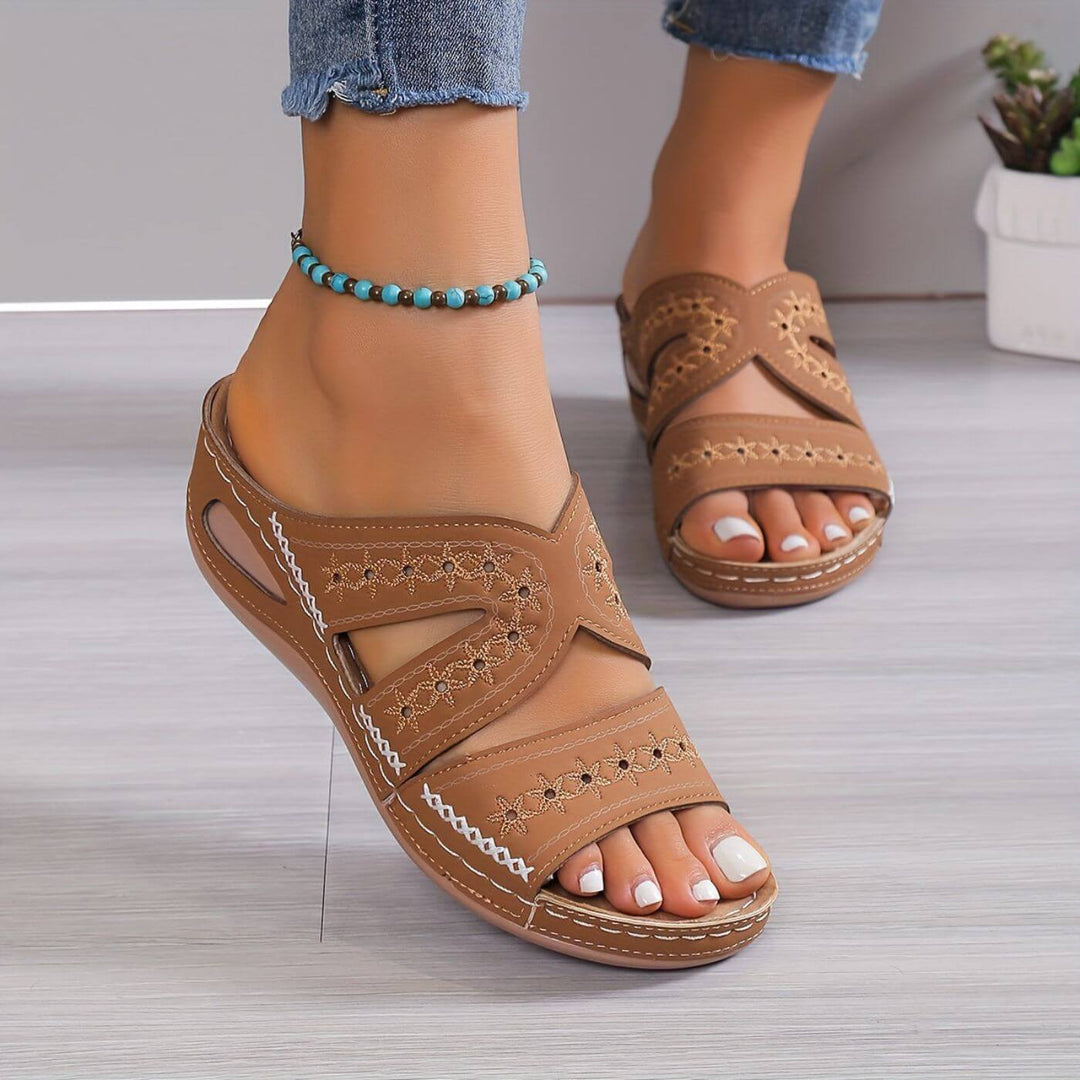  Woman wearing casual open-toe sandals against a plain background.