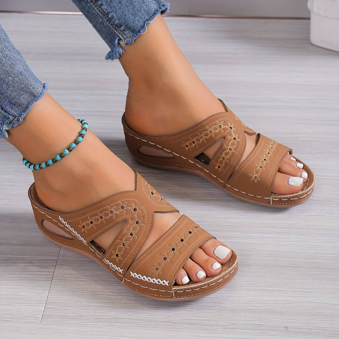  Female model wearing lightweight sandals against a plain background.