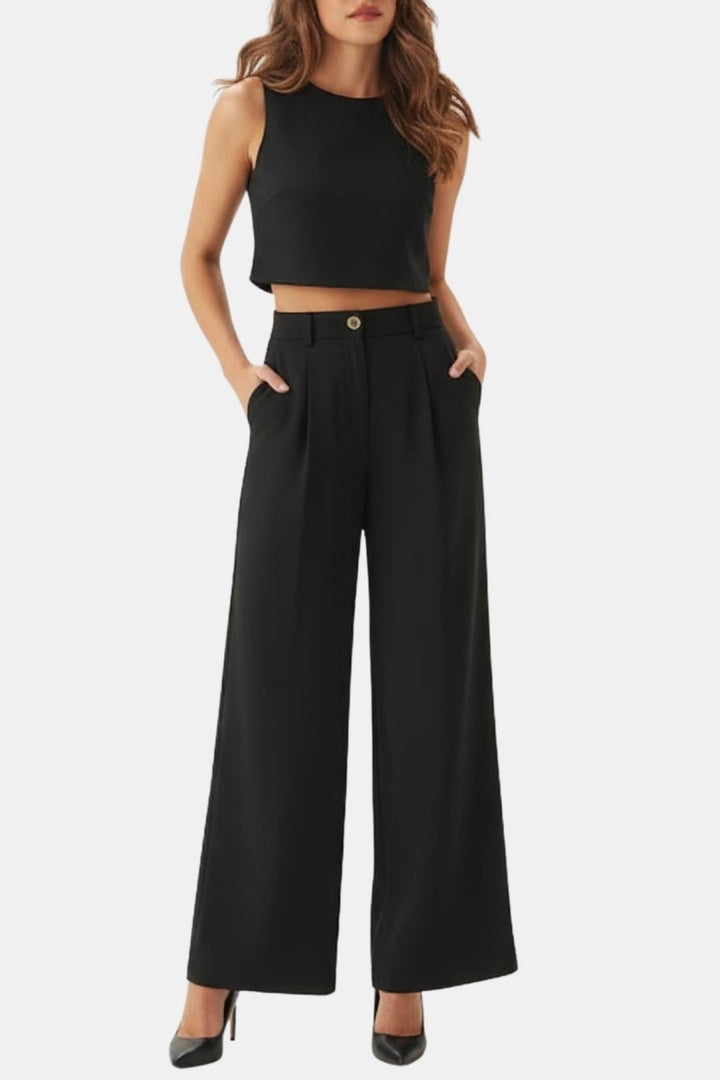 Female model wearing a sleeveless crop top with wide-leg pants on a plain background.