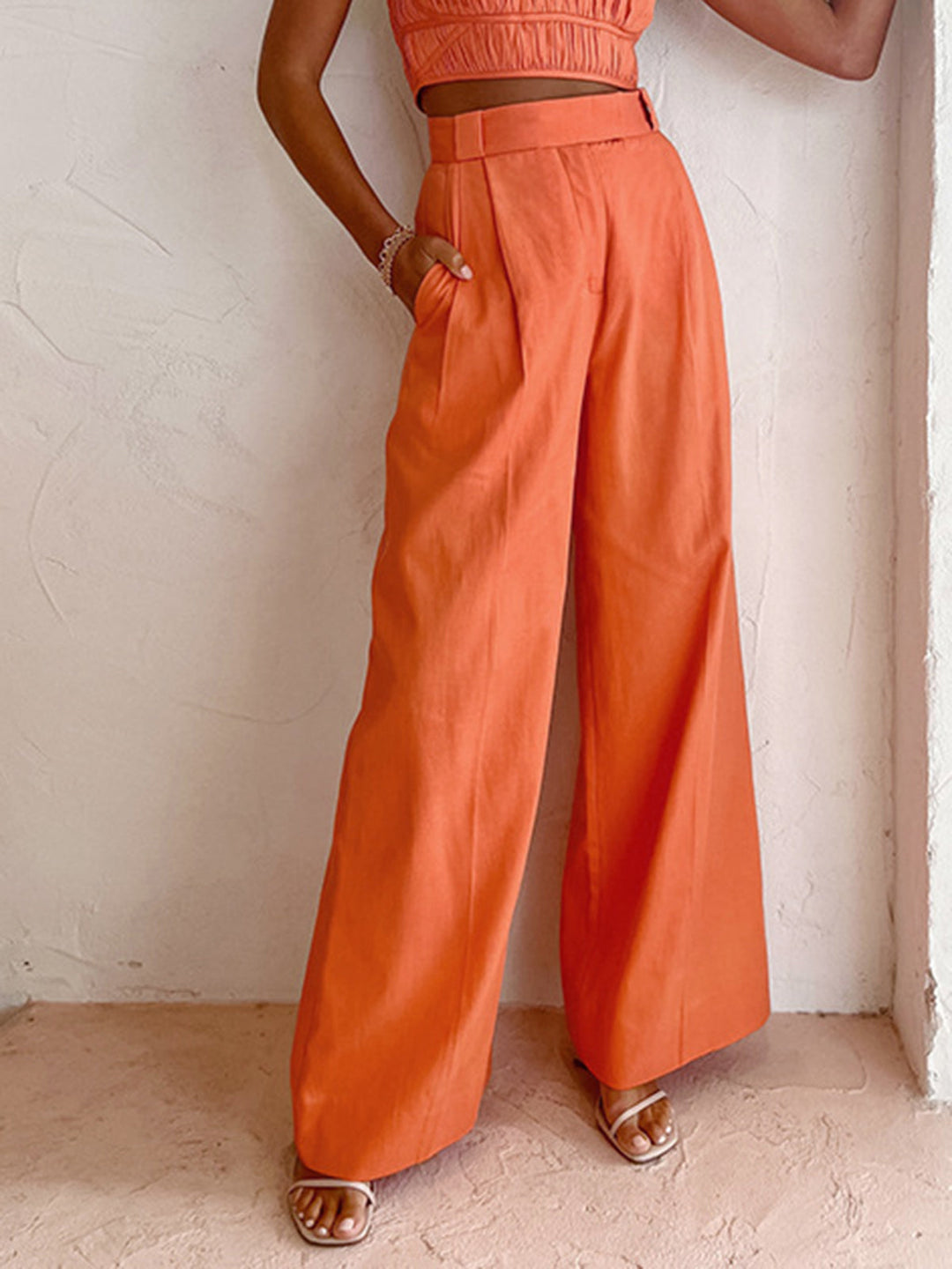 Female model in lightweight long pants on a plain background.