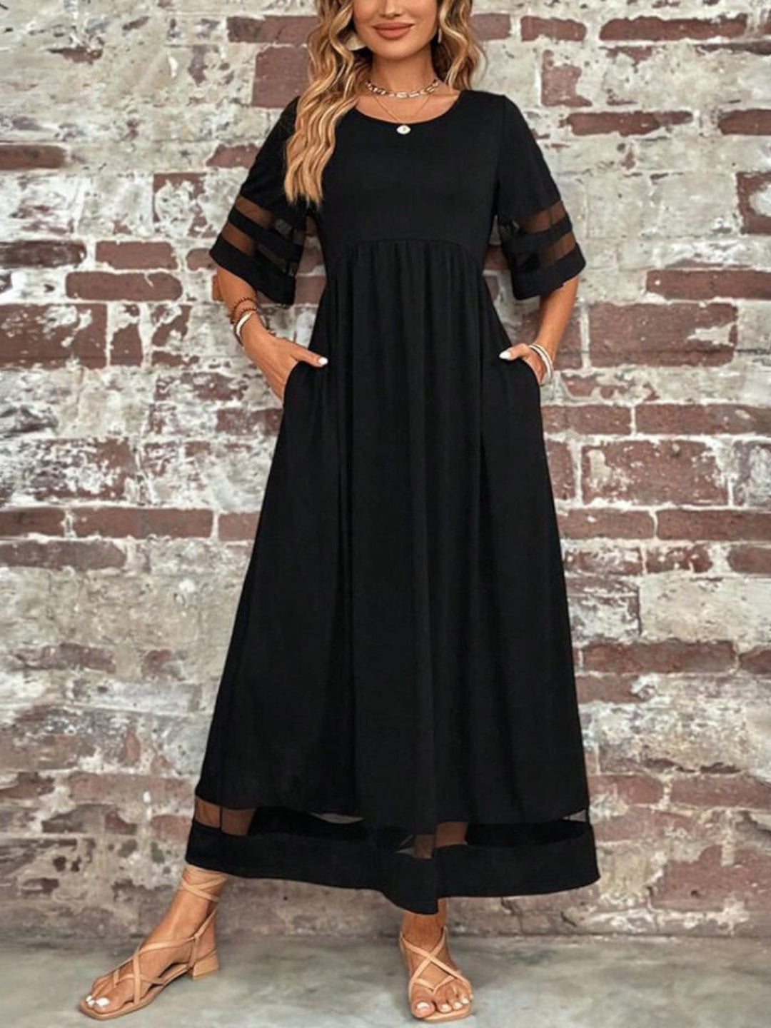 Front pose model in black dress near textured wall brick
