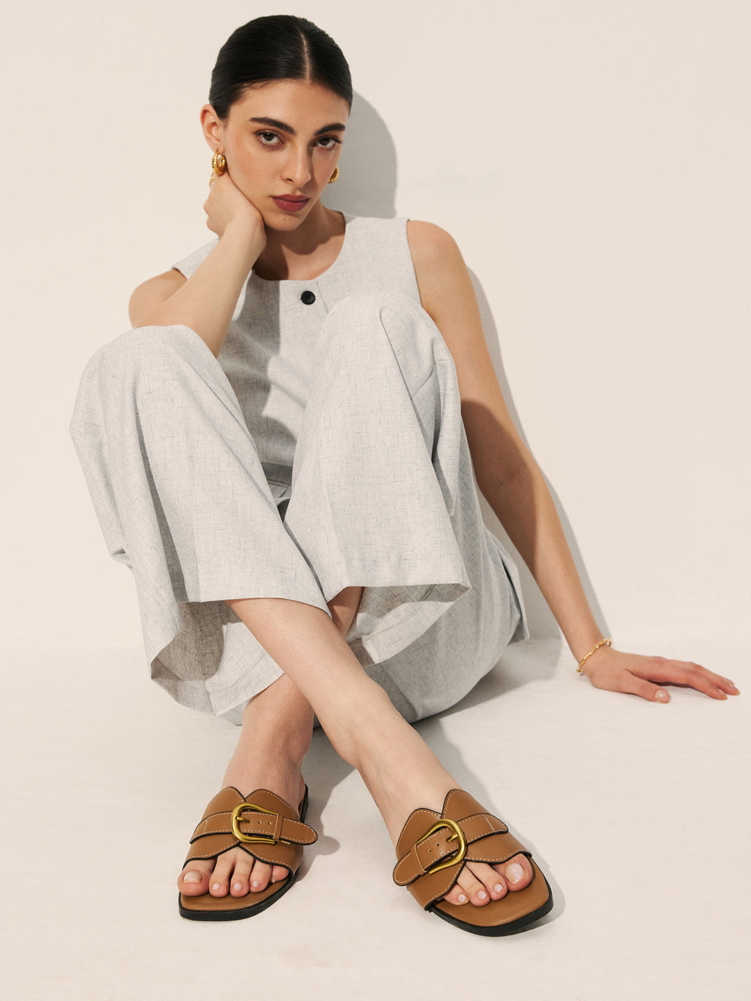 Foot wearing sandals front angle on plain background clean view