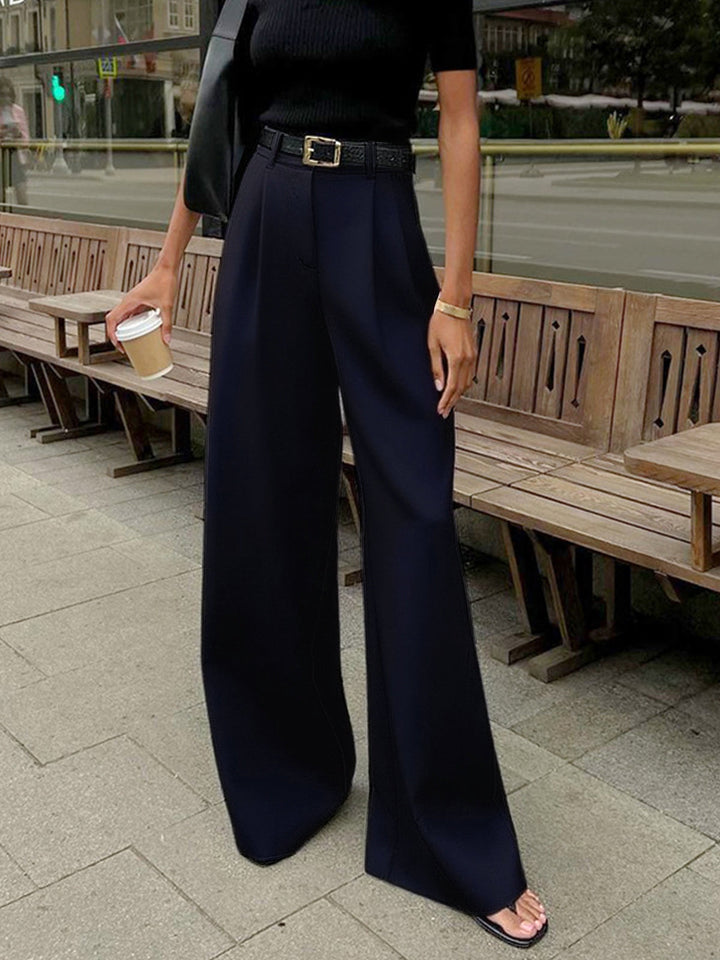 Woman wearing regular fit pants for work and casual wear on a plain background.