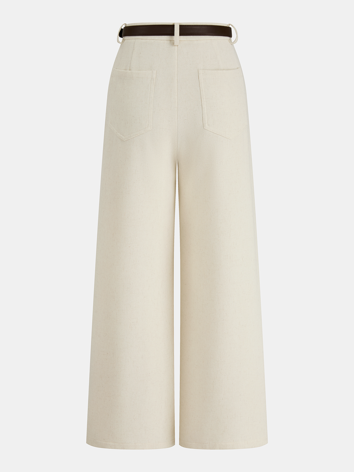 Woman styled in regular fit belted trousers with a clean straight silhouette on a plain background.