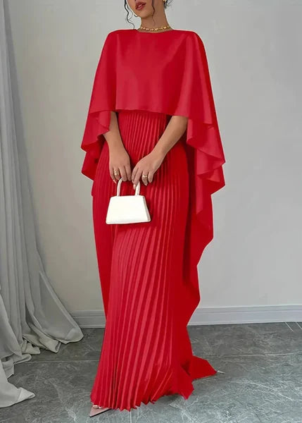 Female model walking showing movement of pleated dress gray background