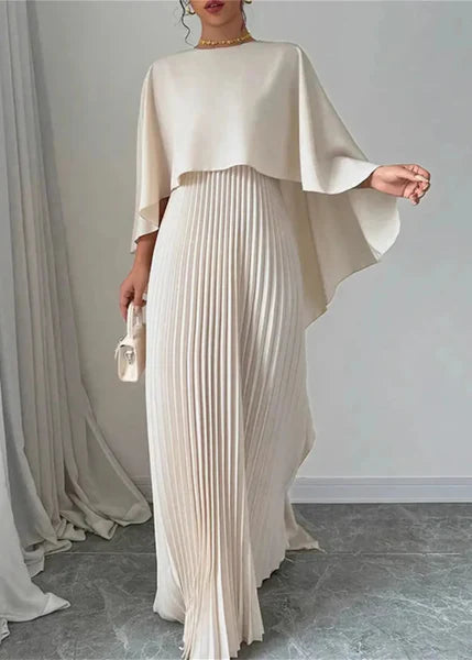 Woman wearing pleated cape maxi dress front view gray background