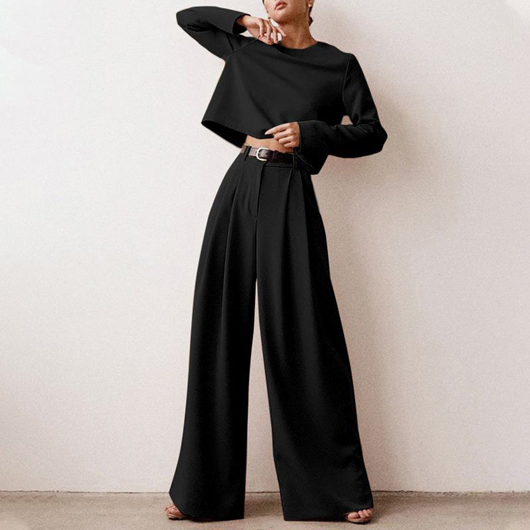 Female model wearing a long-sleeve cropped top with wide-leg pants on a plain background.