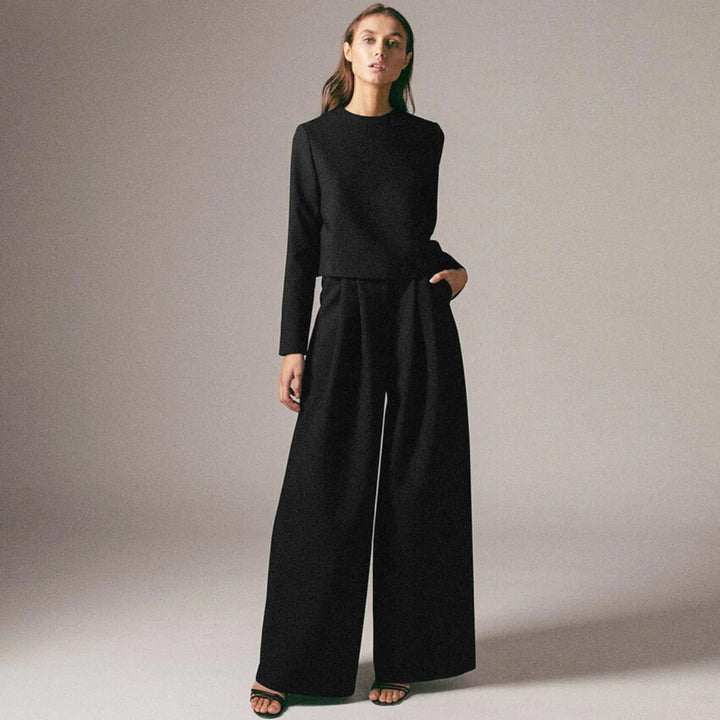 Female model posing in a relaxed wide-leg pants set on a plain background.