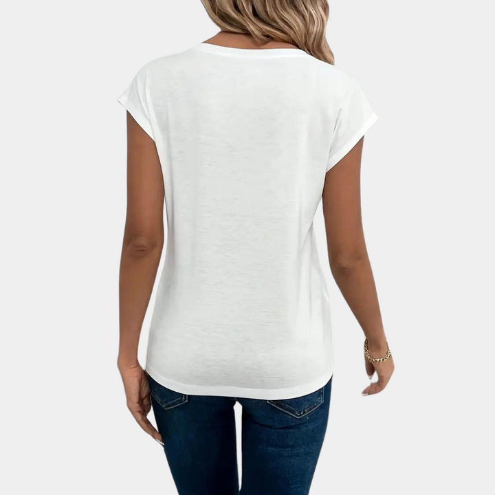 Female model displaying relaxed fit shirt back, plain background.