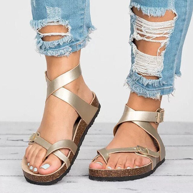Woman showcasing casual adjustable sandals against a plain background.