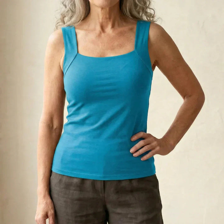 Female showcasing a fitted top with a structured shape on a plain background.