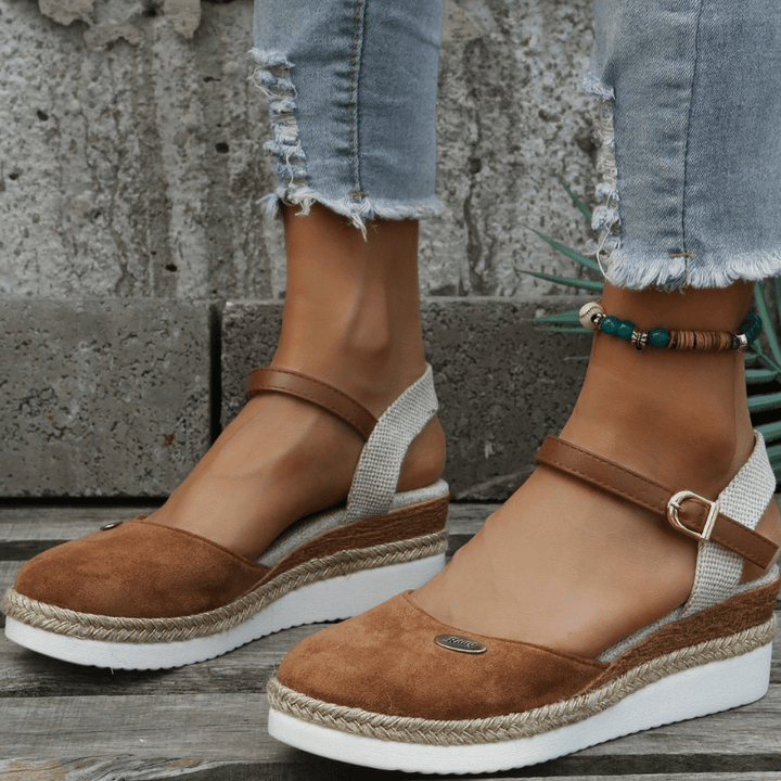 Foot model showing adjustable buckle sandals on plain background