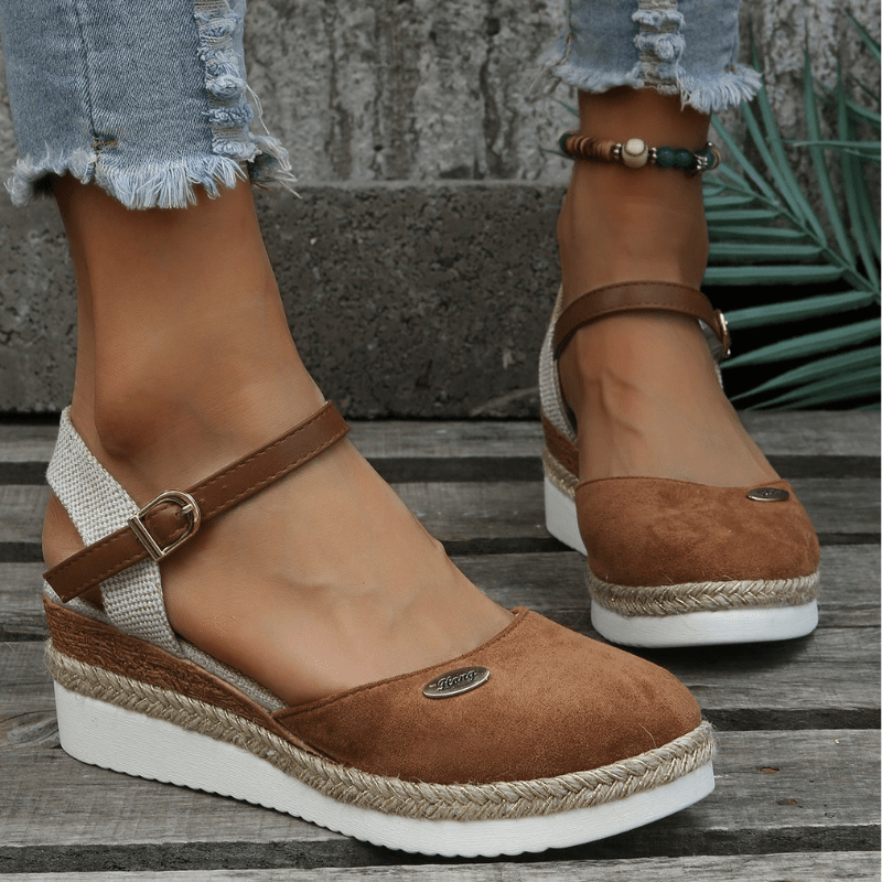Foot model wearing wedge sandals on clean neutral background view