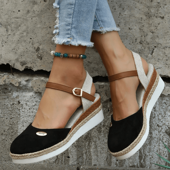 Foot model wearing buckle strap sandals in standing pose