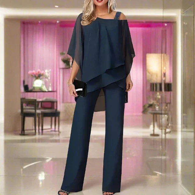Female model showcasing a polished matching outfit on a plain background.