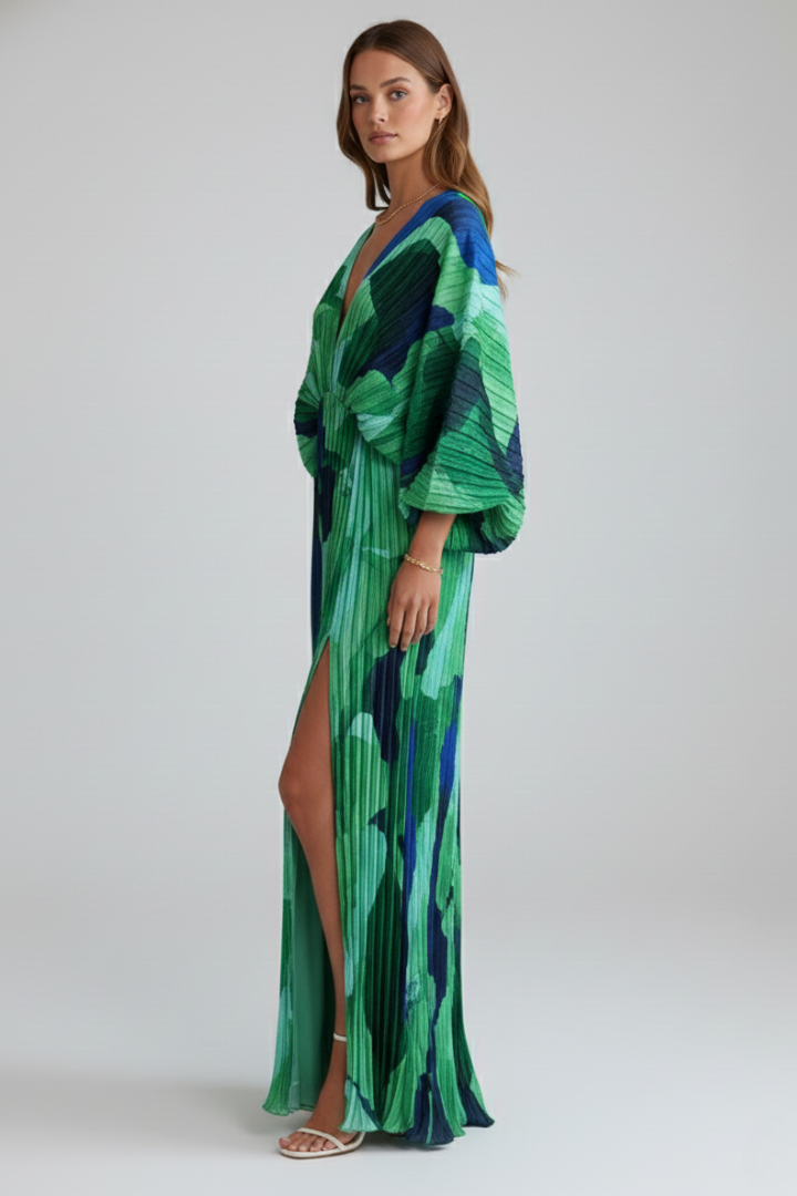Woman showing side angle of printed long dress on gray.
