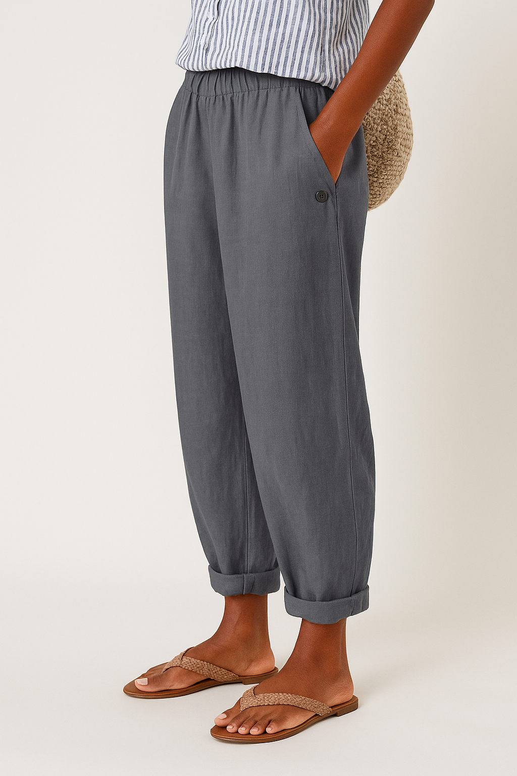  Model displaying tapered cropped trousers with side pockets on a plain background.
