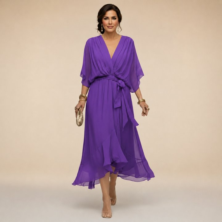 Female in a stylish midi wrap dress with tie waist on a plain background.