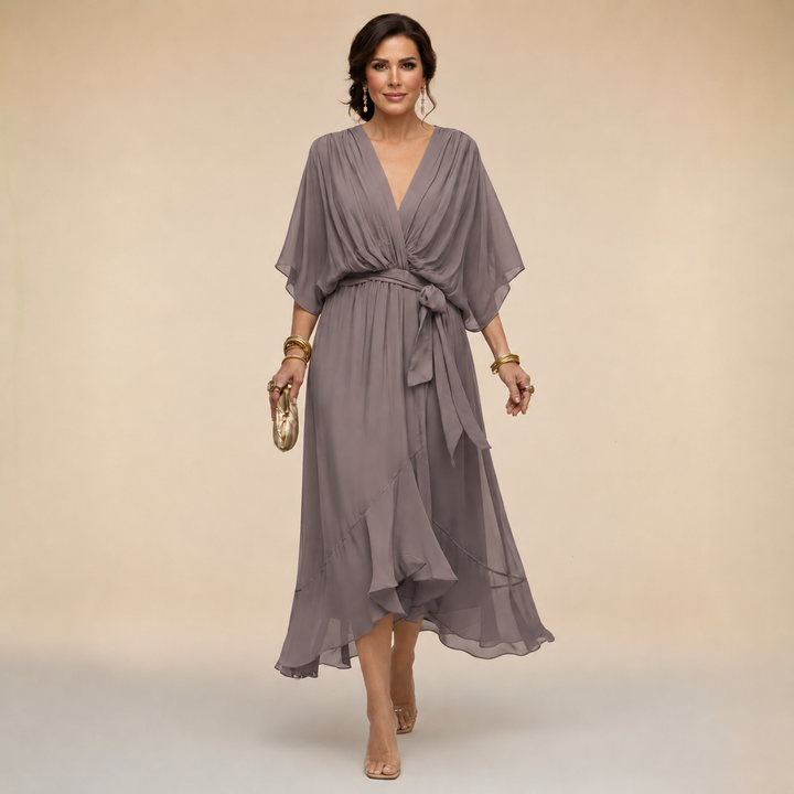 Wrap style midi dress with clean neckline on a plain background.
