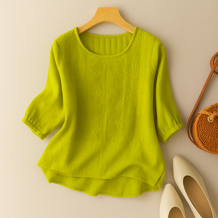 Casual embroidered blouse with short sleeves on a plain background.