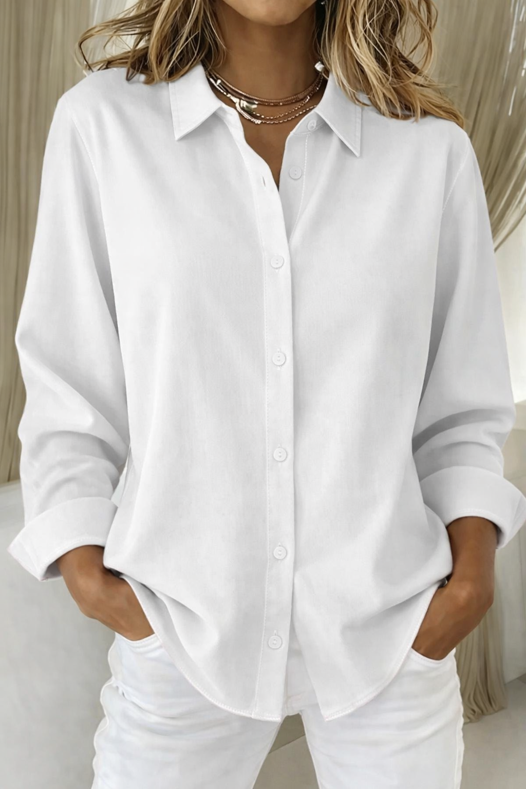 
Female wearing a collared top with a relaxed silhouette on a plain background.