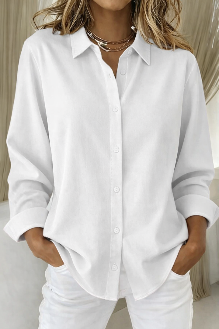 
Female wearing a collared top with a relaxed silhouette on a plain background.