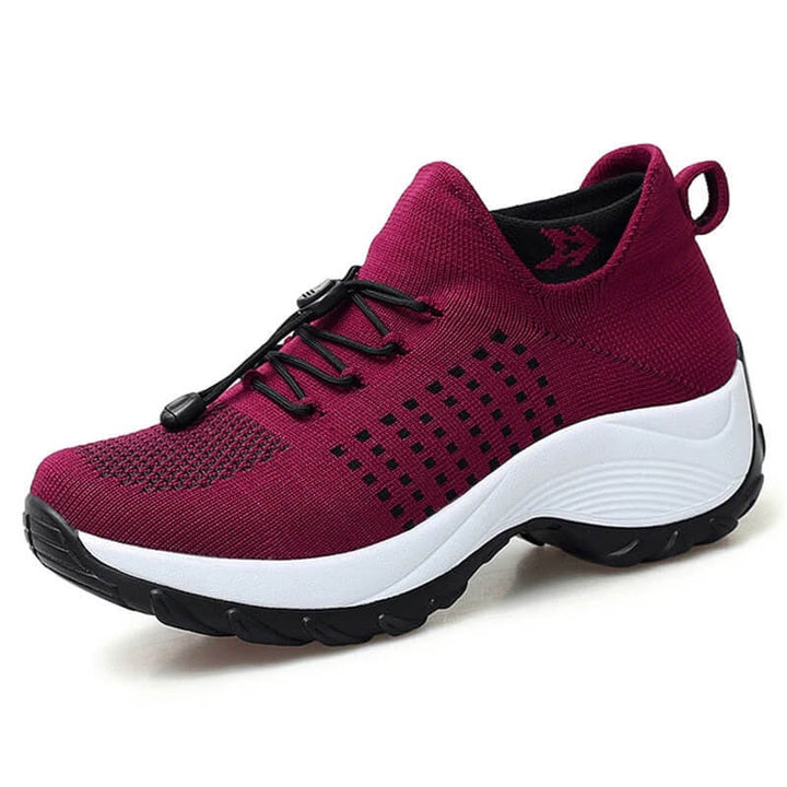 Side profile athletic red sneakers with thick cushioned bottoms