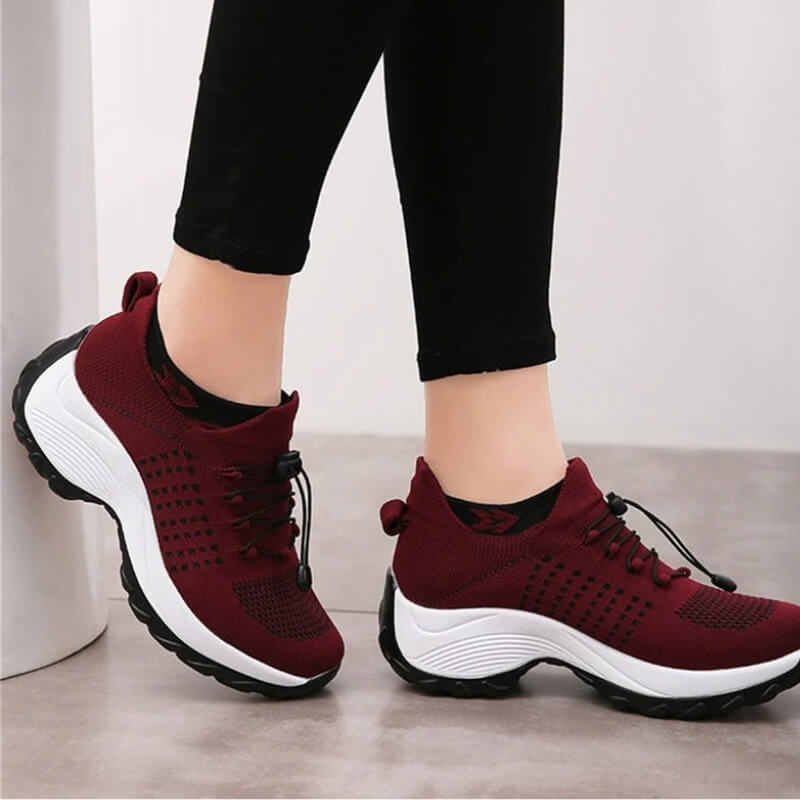Maroon athletic shoes worn with black leggings indoors