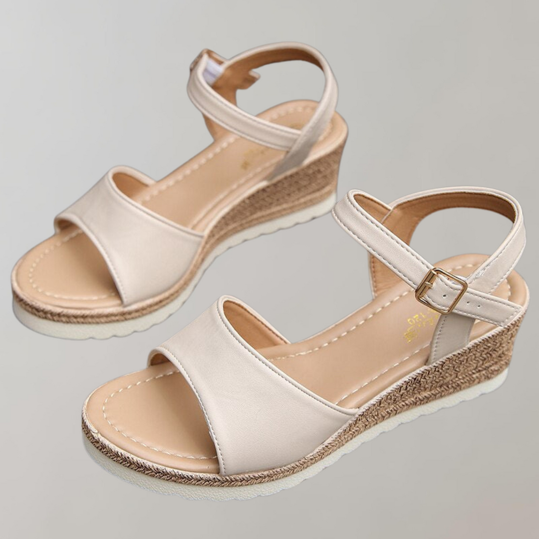 Female wearing breathable wedge sandals in a plain background studio setting