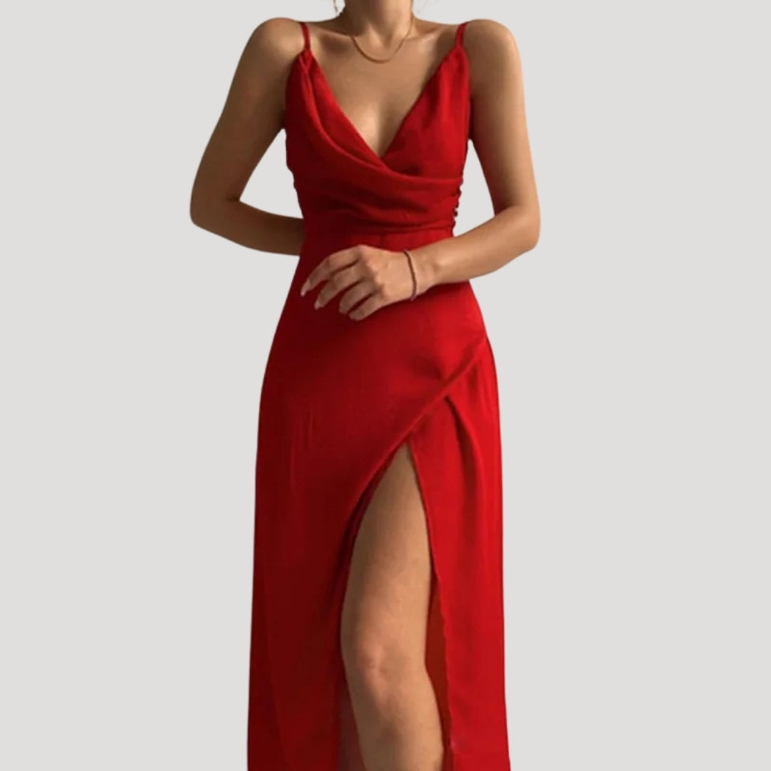 Model posing front view wearing elegant slit dress plain background