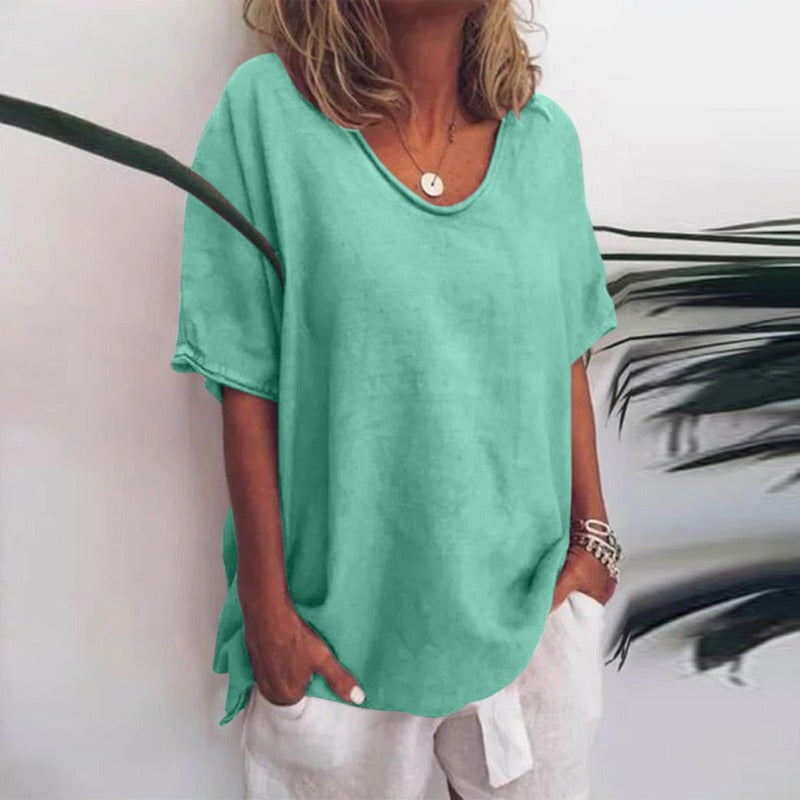 Woman in casual short sleeve blouse on plain background smiling.