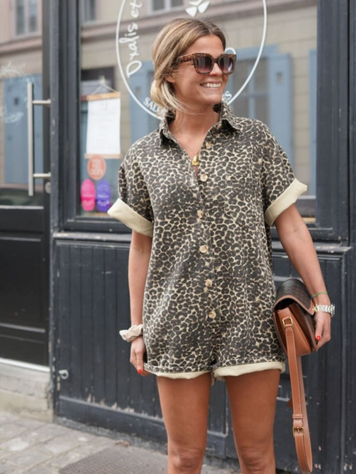 Model standing straight smiling wearing romper plain background clear front detail