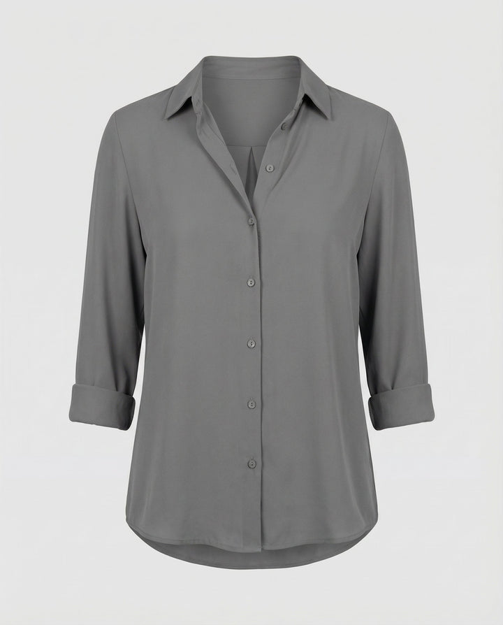 Female model showcasing a relaxed-fit blouse with long sleeves and button fastening.

