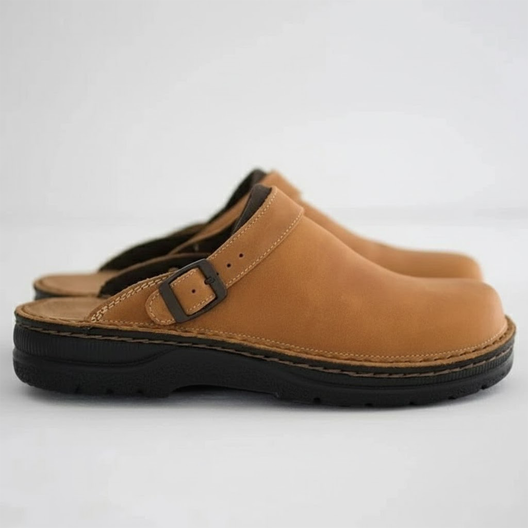 Pair of tan clogs with black soles on a light gray background
