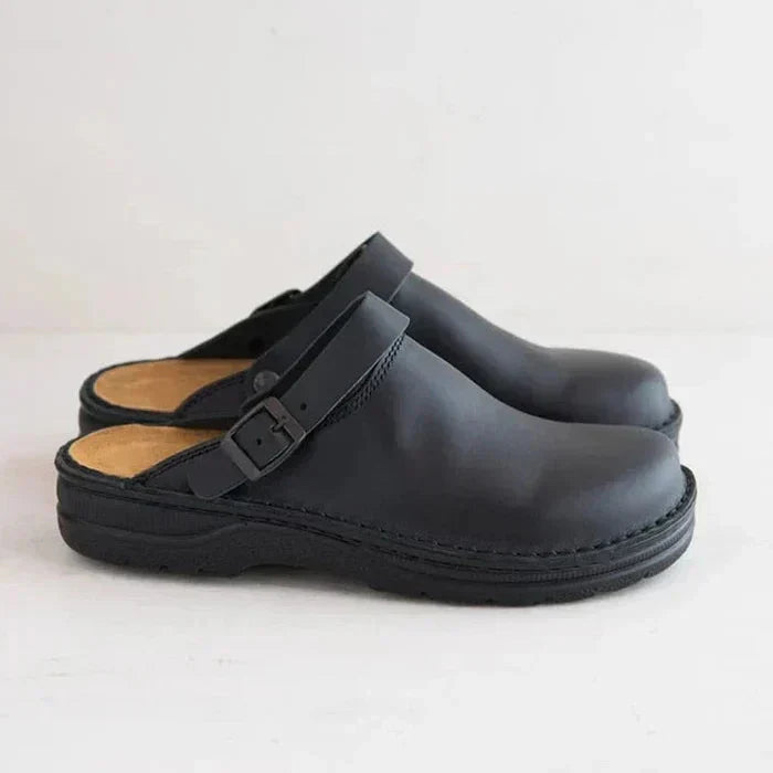 Pair of black clogs on a light gray background
