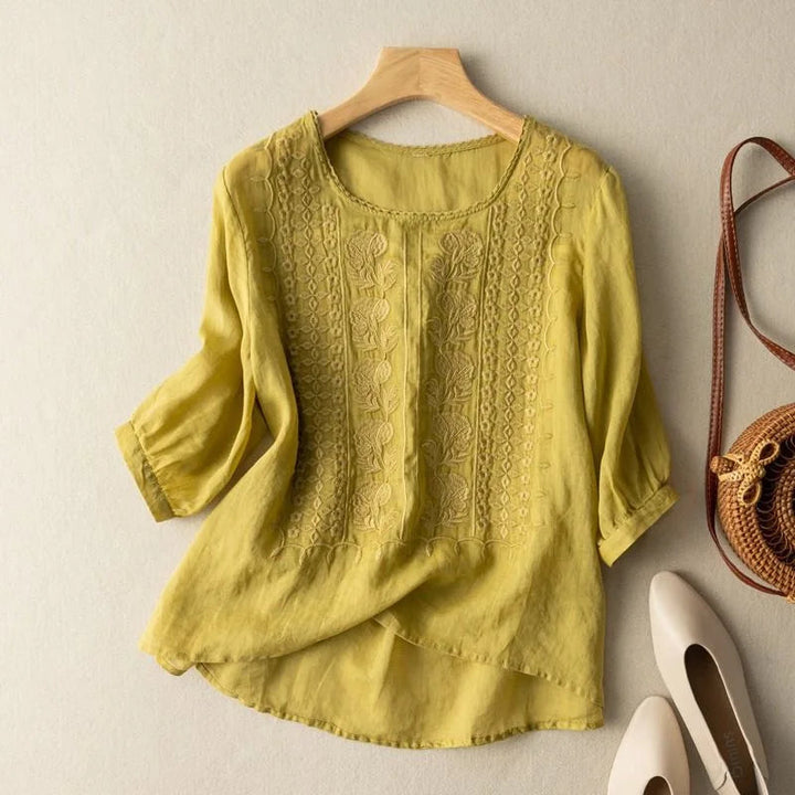 Relaxed-fit blouse with front embroidery and neat cuffed sleeves for casual or work outfits.