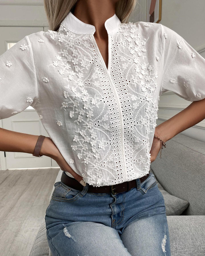 Female wearing elegant embroidered top against clean backdrop