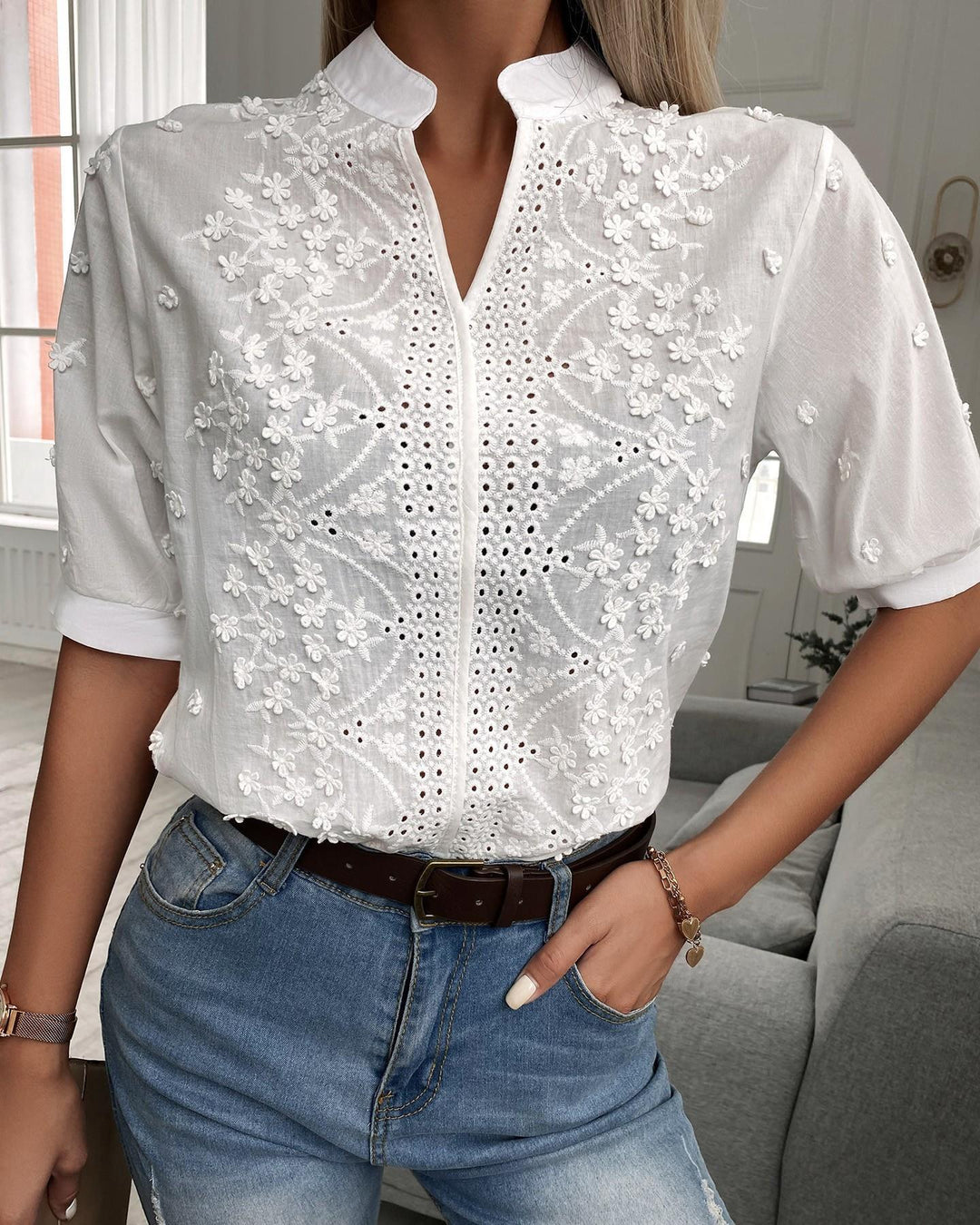 Woman in floral embroidered blouse with plain background