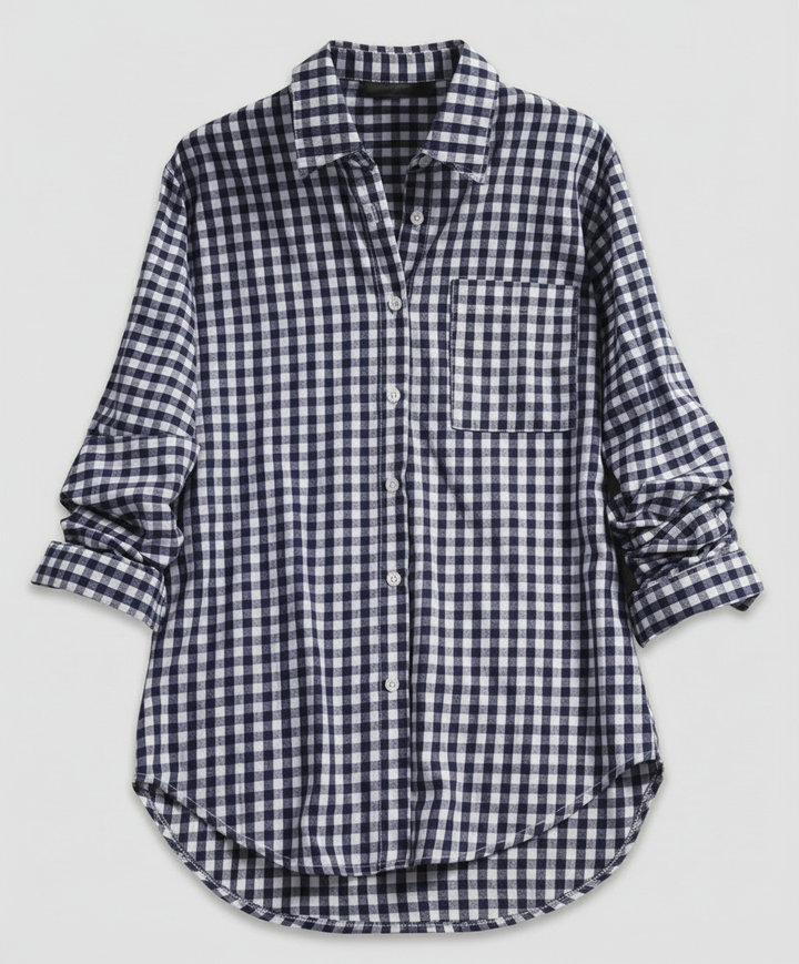 Woman wearing a relaxed-fit plaid shirt with a button-front design on a plain background.