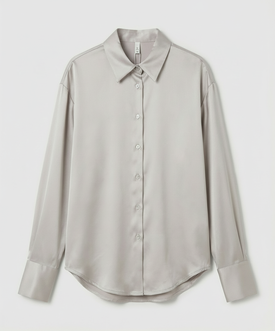 Female in a classic silk shirt styled for everyday wear on a plain background.