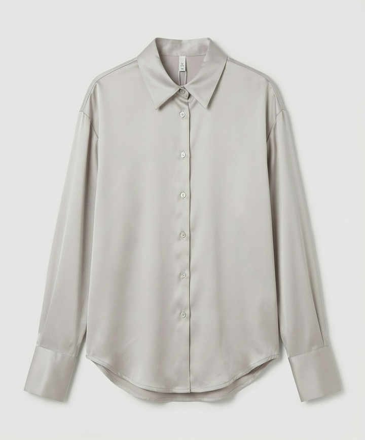 Female in a classic silk shirt styled for everyday wear on a plain background.