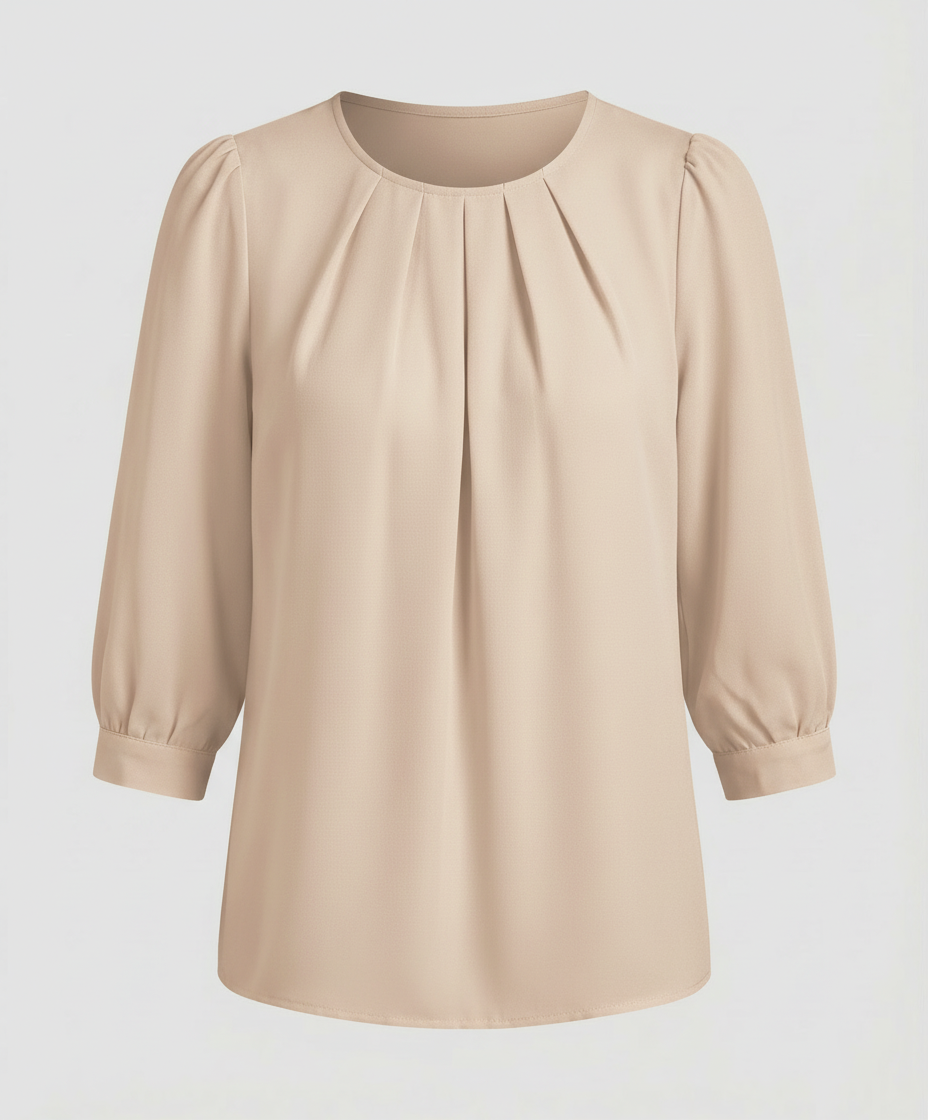 Woman in a satin blouse with elegant pleated accents against a plain backdrop.