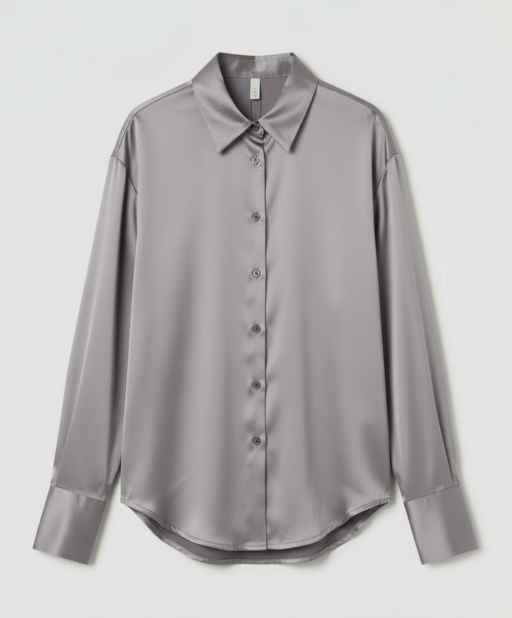 Woman showcasing a long sleeve silk blouse on a plain background.