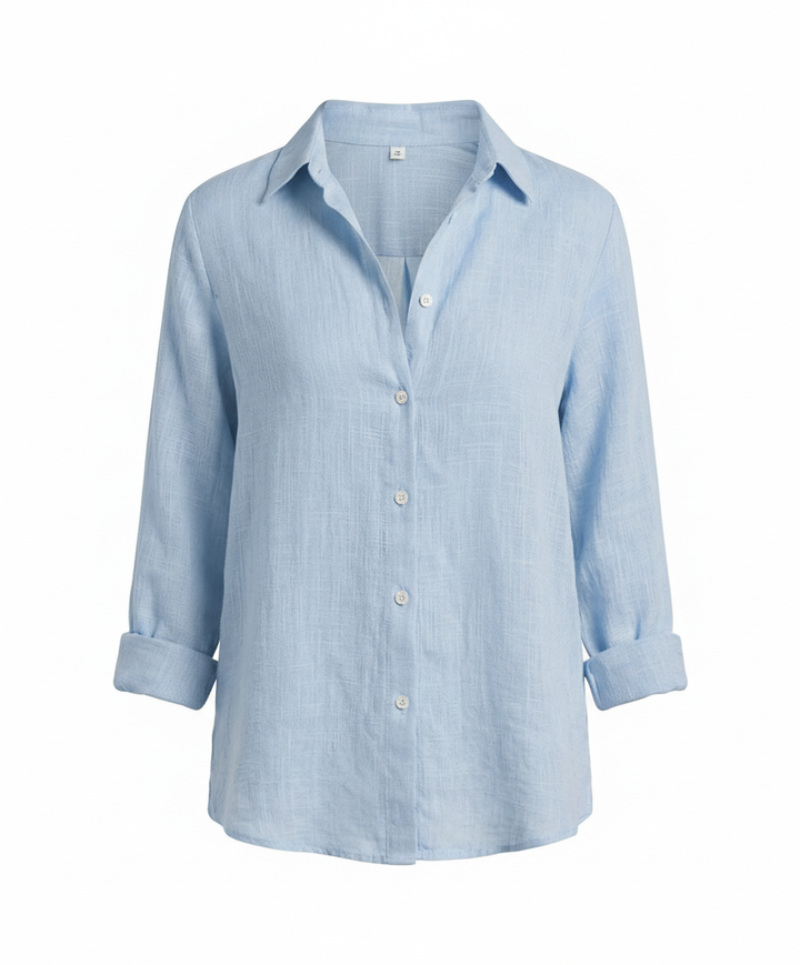 Female model wearing a versatile V-neck top with refined finishing on a plain background.
