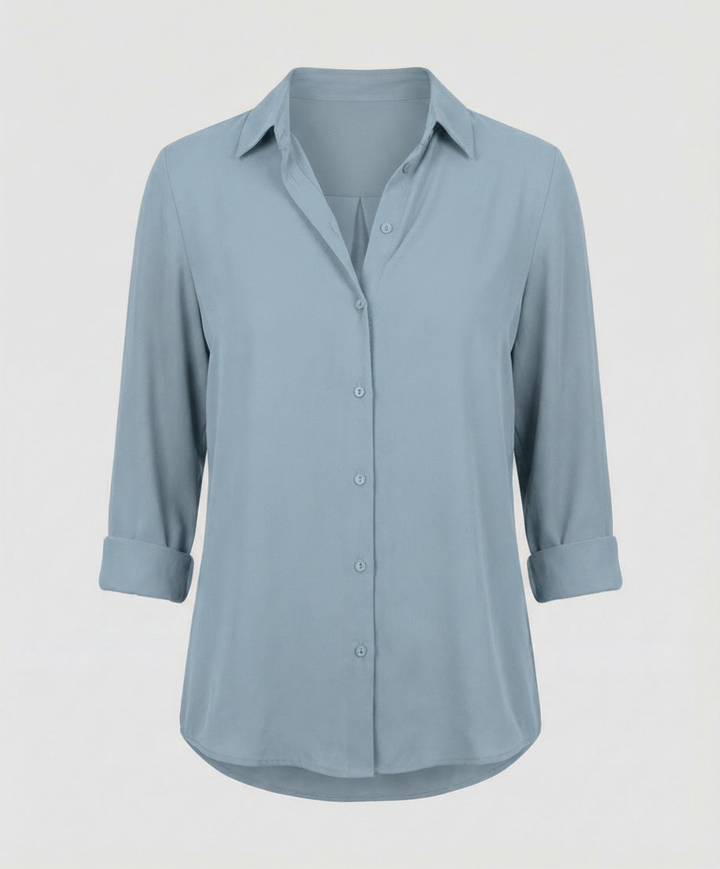 Female model in a classic ladies’ blouse with long sleeves against a plain background.
