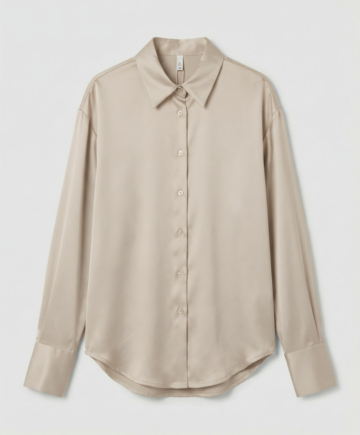 Silk blouse with graceful details on a plain background.