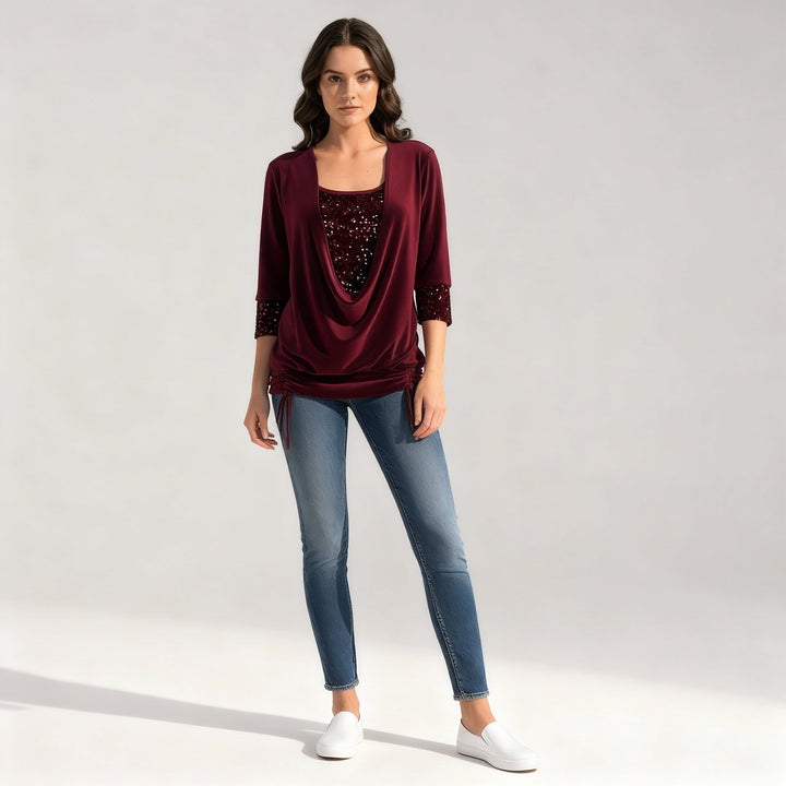 Female model in a solid color sequin blouse on a plain background.